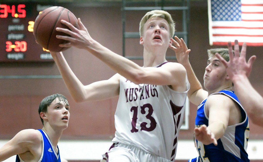 Monmouth Academy's Connor Davies gets a basket over Mt. Abram's defense during a game  Thursday in Monmouth.  