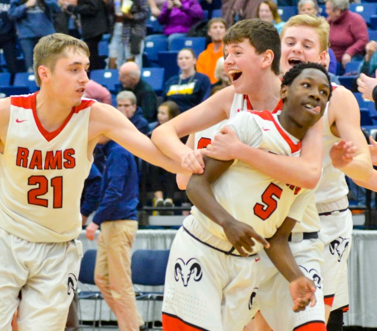 Cony players Bryan Stratton, left, and Luke Briggs run to hug Simon McCormick (5) after the Rams'  73-71 win over Medomak in the Class A North quarterfinals on Saturday at the Augusta Civic Center. McCormick's game winning layup put the Rams on top with seven seconds remaining.