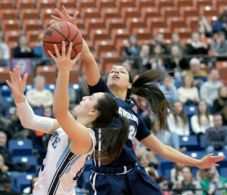 The University of Maine's Blanca Millan goes up for two points under State University of New York at Stony Brook's Hailey Zeise during a basketball game Sunday at the Augusta Civic Center.