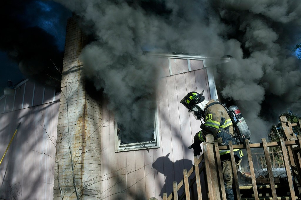 A firefighter exits a home that burned Tuesday on Keith Drive in Chelsea. Firefighters from several departments went to the blaze, which destroyed the residence, according to firefighters, but no injuries were reported.