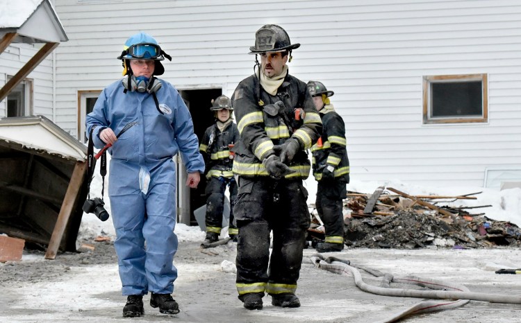 Jeremy Damren, left, of the state Fire Marshals Office, confers with a Skowhegan firefighter while investigating the cause of a fire at 386 Water Street in Skowhegan after fire broke out on Sunday, February 3, 2019. 