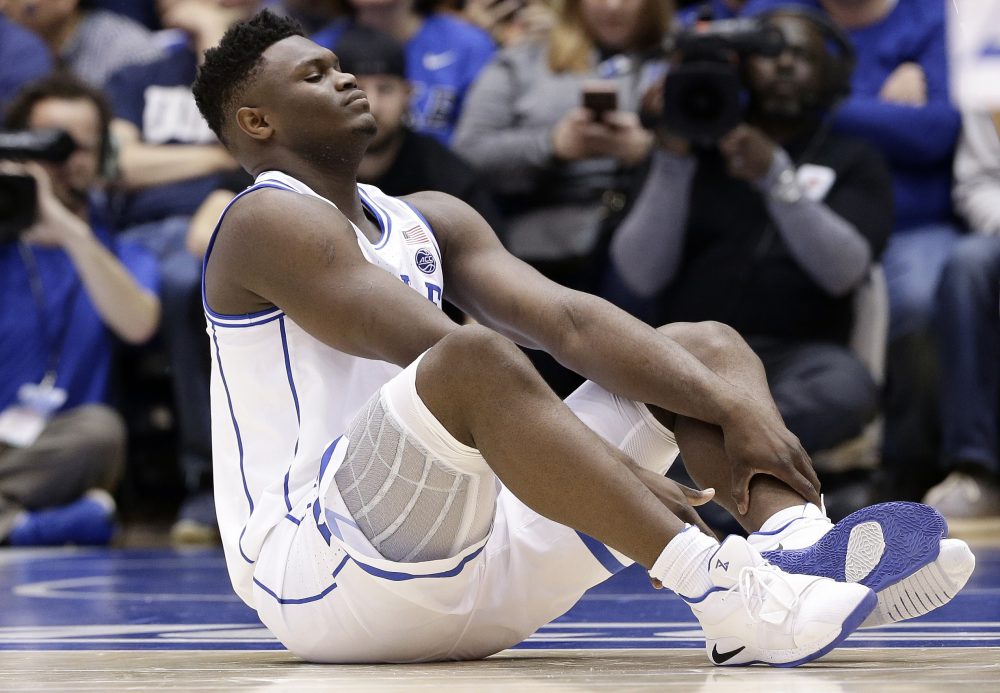 Duke's Zion Williamson sits on the floor following a injury during the first half of an NCAA college basketball game against North Carolina in Durham, N.C., Wednesday, Feb. 20, 2019. (AP Photo/Gerry Broome)