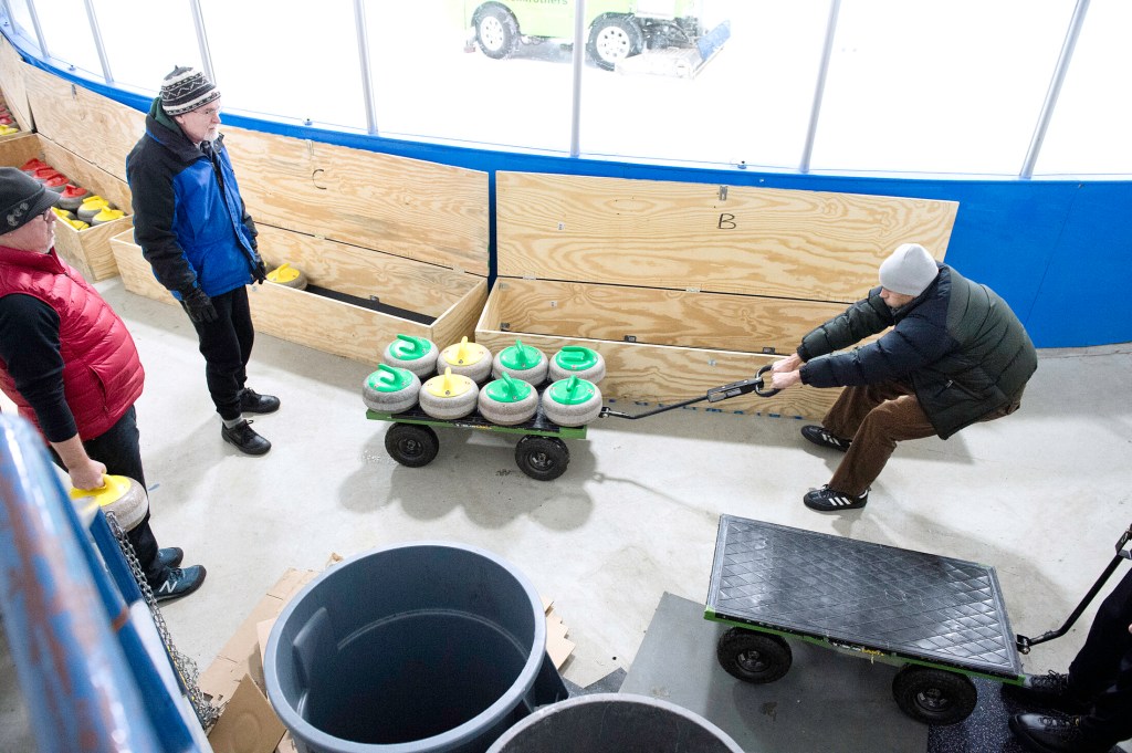 Nick Matluck of Freeport pulls curling stones out of storage at the William B. Troubh Ice Arena in Portland recently. Each stone weighs 42 pounds. 