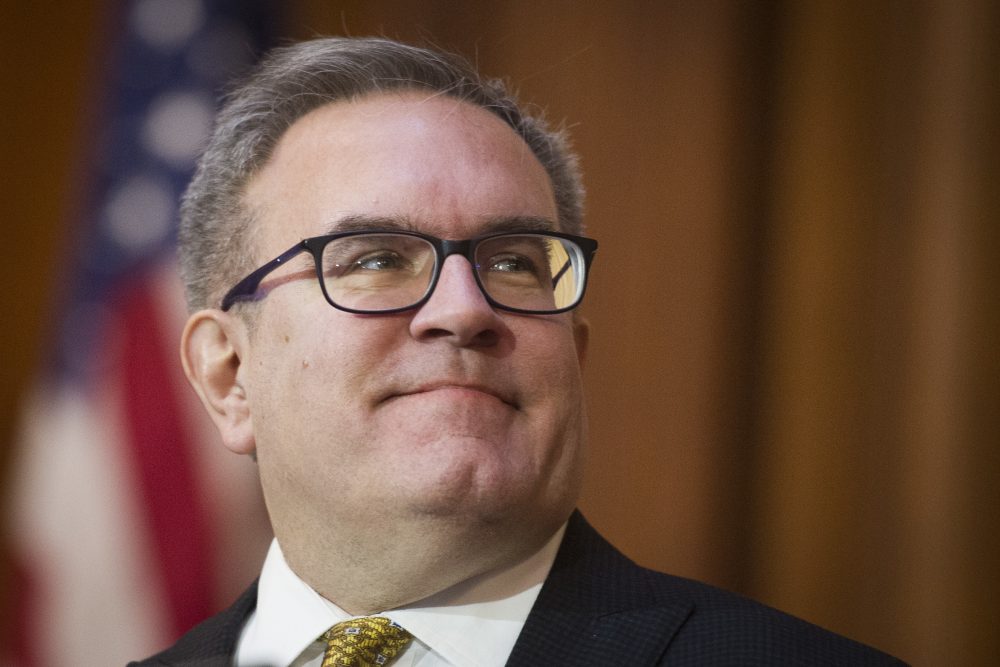 FILE - In this Dec. 11, 2018 file photo, Acting EPA Administrator Andrew Wheeler signs an order withdrawing federal protections for countless waterways and wetland, at EPA headquarters in Washington. A Senate panel voted 11-10 along party lines Tuesday to approve President Donald Trump’s nomination of Wheeler as the country’s top environmental regulator.(AP Photo/Cliff Owen)