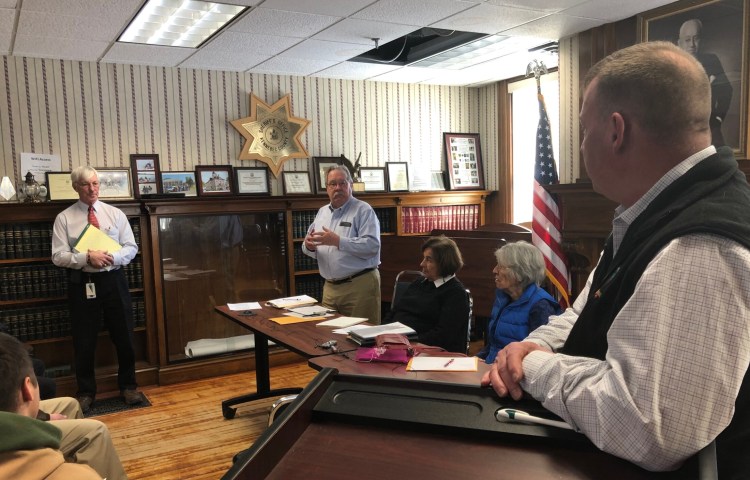 Cliff Wells, director of Emergency Communication for the Maine Department of Public Safety, left, Kennebec County Administrator Robert Devlin and Kennebec County Sheriff Ken Mason talk about law enforcement dispatch options at a meeting Thursday in Augusta, as county commissioners Patsy Crockett and Nancy Rines listen.