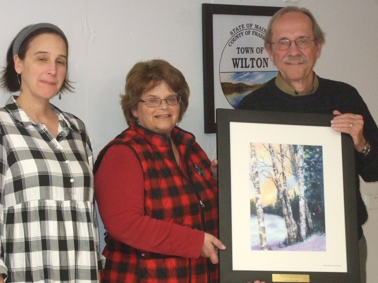Jen Jespersen, left, president of the Maine Lakes Society, with Rhonda Irish, Wilton town manager, accepting the painting from Rob Lively.   