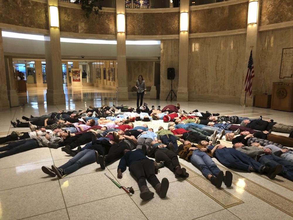 Student advocates for new gun safety regulations hold a silent "lie-in" protest in the state Capitol in Santa Fe, N.M., on Wednesday, Feb. 13, 2019, in anticipation of the anniversary Thursday of the mass shooting at Marjory Stoneman Douglas High School in Parkland, Fla. Some wore T-shirts bearing the names of individuals killed in Parkland. The New Mexico House of Representatives was poised to vote on a bill that would make it easier to take guns away from people who may be suicidal or bent on violence. (AP Photo/Morgan Lee)
