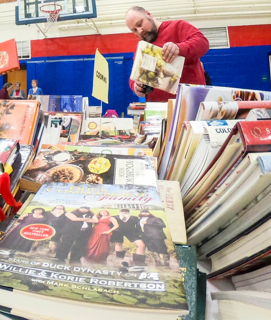 BELGRADE, ME - MARCH 2: Shoppers browse cook book section during Friends of the Belgrade Library book sale on Saturday March 2, 2019 in the Belgrade Central School gym. (Staff photo by Joe Phelan/Staff Photographer)