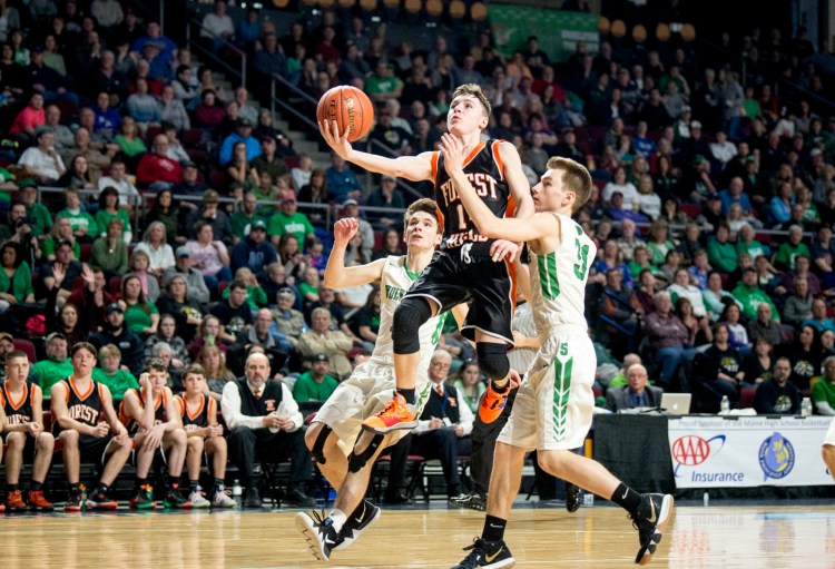 Forest Hills' Parker Desjardins (14) drives to the basket as  Schenk's Andrew Goula defends during the Class D state championship game last season at the Cross Insurance Center in Bangor.