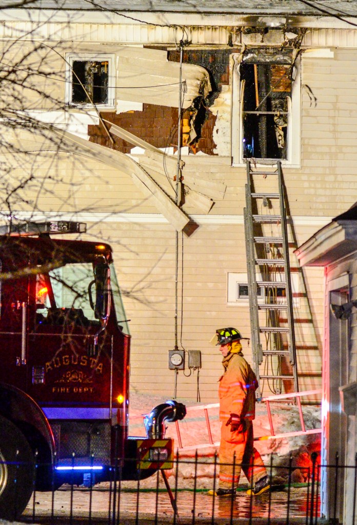 A firefighter carries a ladder back to a truck as they clear up at 6:06 p.m. after putting out a fire at 11 Densmore Court on Saturday in Hallowell. The fire was in a two-story residence at the end of Densmore Court, a short, dead-end street off Wilder Street, near Bolley's Famous Franks. The call came in at 4:24 p.m., and Augusta, Gardiner, Farmingdale and Randolph were some of the departments that responded as mutual aid. Water Street was closed between Winthrop and North streets.