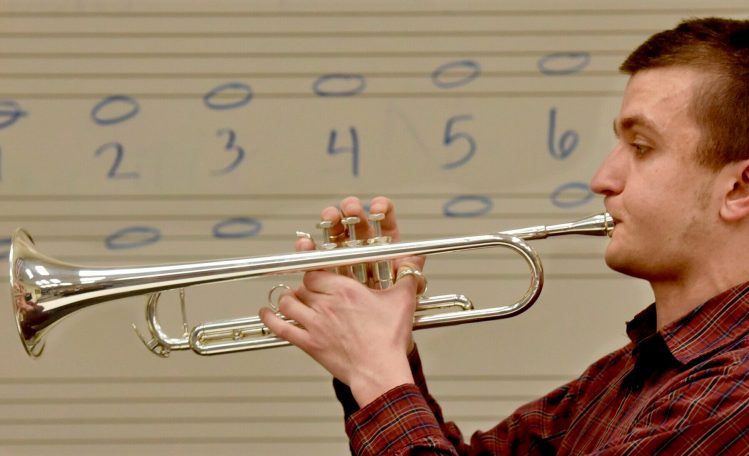Lawrence High School senior Nathanael Batson plays his trumpet in front of a board scripted with whole notes on Thursday. Batson is the recipient of the 2019 Section 1 "Heart of the Arts" award. He is legally blind and memorizes the music he plays.