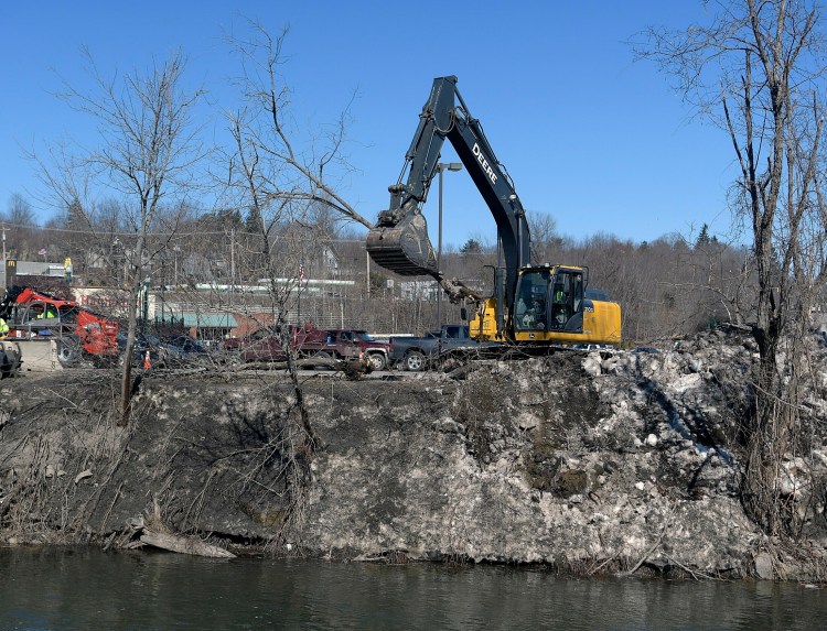 Invasive trees are removed Monday from the banks of Cobbosseecontee Stream in Gardiner as part of the the Department of Transportation project to replace two bridges crossing the stream.