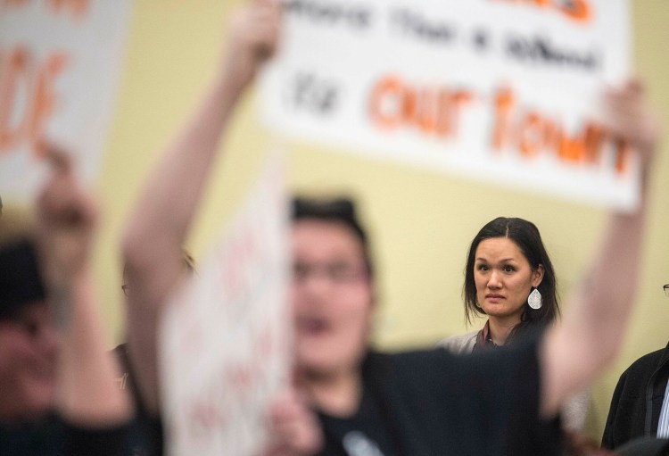A woman who did not want to be identified listens Thursday as a majority of people in attendance for a school board meeting at Skowhegan Middle School cheer for the "Indians" sports teams nickname.