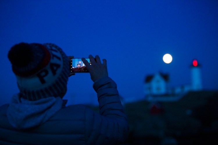 Michael Cabelin of York takes a photo of a full moon rising over Nubble Light on March 20.