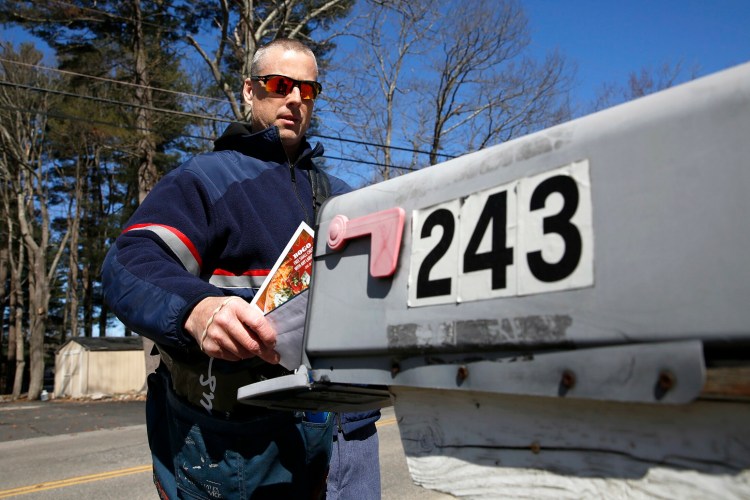 John Graham delivers mail Wednesday in Portland's North Deering neighborhood. Staffing shortages at the post office have caused delays in mail delivery for some residents in southern Maine.