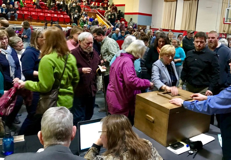 Gov. Janet Mills, right center, casts her ballot along with other Farmington residents who voted on whether to support the NECEC project Monday at the town meeting. The vote was 262-102 to oppose the project. Morning Sentinel photo by Rachel Ohm