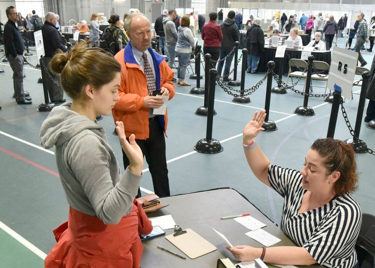 Colby College student Alexandria Fraize, left, swears the information she gave election clerk Allison Brochu is accurate before voting at Thomas College on Tuesday, Nov. 6, 2018. City Solicitor Bill Lee observes. After an effort to disqualify the votes of Colby College students in the November election was dismissed by the Maine Supreme Judicial Court, an appeal has been lodged with the city of Waterville's Voter Registration Appeals Board.