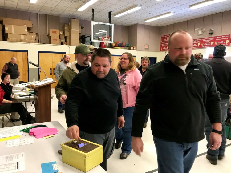 Canaan resident Ford Nelson, center, casts a ballot Saturday at Town Meeting at Canaan Elementary School.