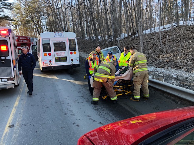 Emergency responders tend to the driver of a Chevy sedan that collided with a Colby College shuttle on North Street Hill on Monday.