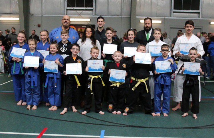 Members from Huard's Martial Arts in Winslow participated March 23 during the 39th Battle of Maine Martial Arts Championships at Thomas College In Waterville. They helped raise close to $5,000 for the Children's Miracle Network. In front, from left, are Mikayla Achorn, Lucia Lacroix, Ayden Karstens, Keegan Miranda, Quincy Schneider, Preston Schneider, Logan Dow and Jaden Tavares.  
In back, from left, are Carlie Bertrand, Abby Dudley, Mason Bumba, Event Promoter Mark Huard, Philanthropy Officer Nicole Trainor, Waterville Mayor Nick Isgro, Luke Raven, Olivia Rando, H & R Block Owner Cory Dow, Nicolas Thibault and Pedro Natario.