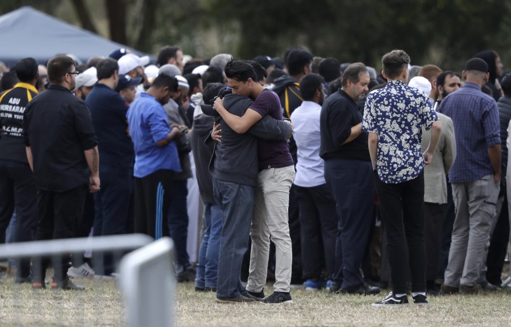 Mourners react as they carry the body of a victim of Friday March 15 mosque shootings for a burial at the Memorial Park Cemetery in Christchurch, New Zealand, Wednesday, March 20, 2019. (AP Photo/Mark Baker)