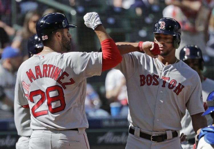 Xander Bogaerts, right, greets J.D. Martinez after Martinez hit a three-run homer Sunday in Seattle. Bogaerts reportedly is nearing a six-year extension with the Red Sox. 

