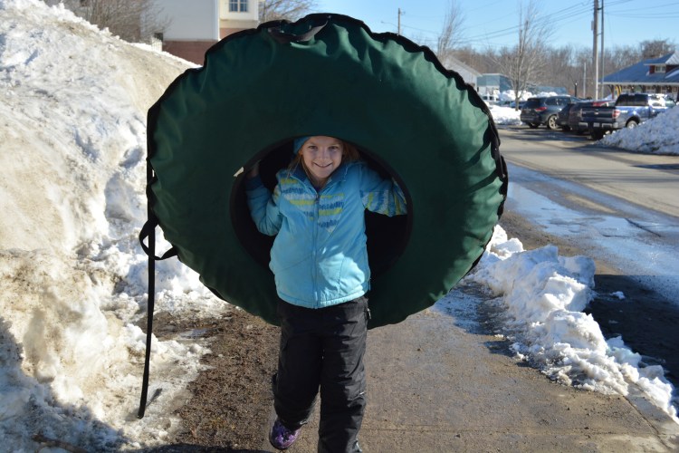 Avery Tinker carries a snow tube during a previous Fire and Ice Festival in Farmington. Those you don't have a snow tube, you can pick one up on Franklin Savings Bank’s Front Street lawn during the festival.