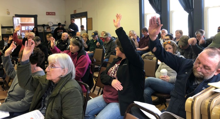 Burnham residents vote on an article in the town warrant at Saturday's annual Town Meeting. Over 35 citizens participated this year.