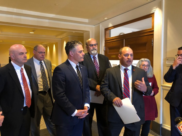 Portland Mayor Ethan Strimling, left center, and Auburn Mayor Jason Levesque, right center, address reporters at the State House on Wednesday about a bill that would allow cities and towns to create a local sales tax.