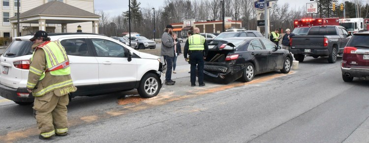 Waterville police and firefighters attend to the aftermath of a three-vehicle accident Wednesday on Kennedy Memorial Drive in Waterville.