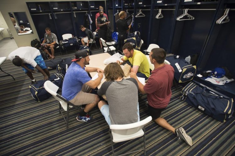 Members of the Biloxi Shuckers minor league baseball team eat lunch before practice at the Pensacola Blue Wahoos' stadium in Pensacola, Fla. Minor leaguers at the lowest levels can make as little as $1,100 per month despite spending 50-to-70 hours per week at the ballpark. 