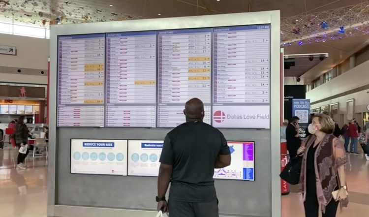 Passengers look for information on their flights Sunday at Dallas Love Field.