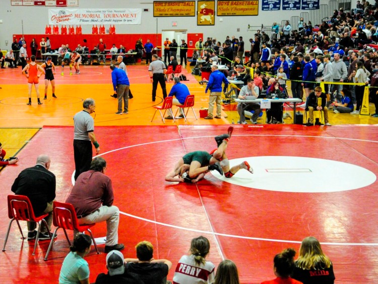 High school wrestlers take part in a conference championship at Cony High in Augusta in 2018. The Maine Principals' Association is reconsidering its decision that wrestlers must be fully vaccinated this winter.