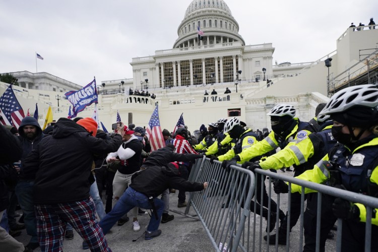 Trump supporters try to break through a police barrier at the Capitol in Washington on Jan. 6, 2021. Evan Neumann of Mill Valley, Calif., who faces criminal charges for participating in the riot, is seeking asylum in Belarus, the country's state TV reported on Monday.