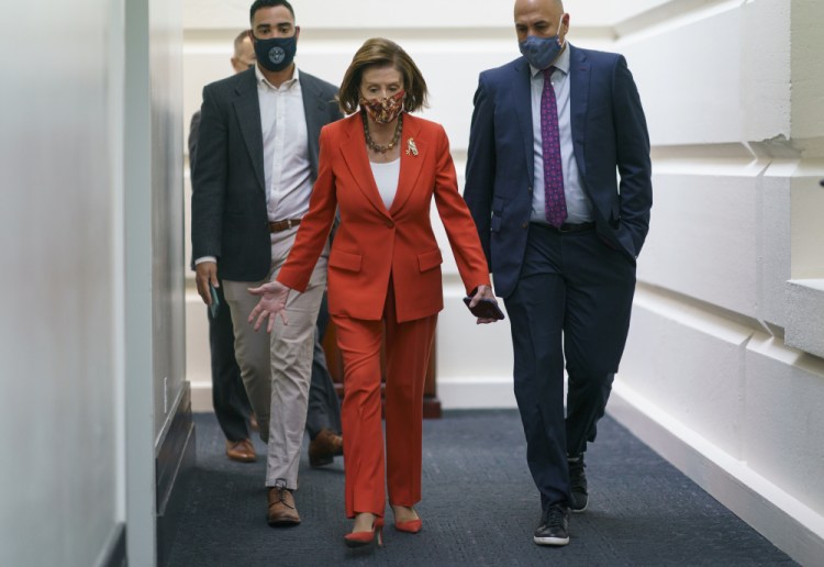 Speaker of the House Nancy Pelosi, D-Calif., arrives to meet with the Democratic Caucus at the Capitol in Washington, early Tuesday. Even as Sen. Joe Manchin, D-W.Va., is wavering over supporting President Biden's $1.75 trillion domestic policy package, Democratic leaders are vowing to push ahead, with voting possible on the bill this week. 