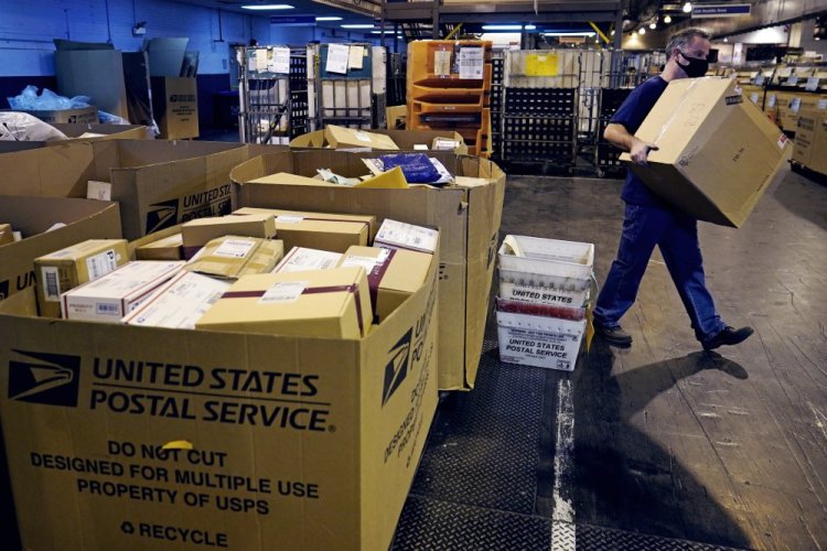 A worker carries a large parcel at the United States Postal Service sorting and processing facility in Boston this month. Last year's holiday season was far from the most wonderful time of the year for the beleaguered U.S. Postal Service. Shippers are now gearing up for another holiday crush.