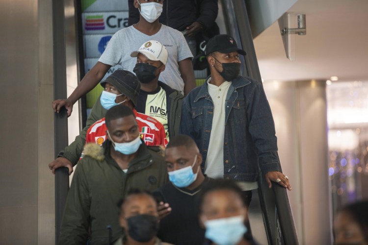 People wearing masks on an escalator at a shopping mall, in Johannesburg, South Africa, Friday. 
