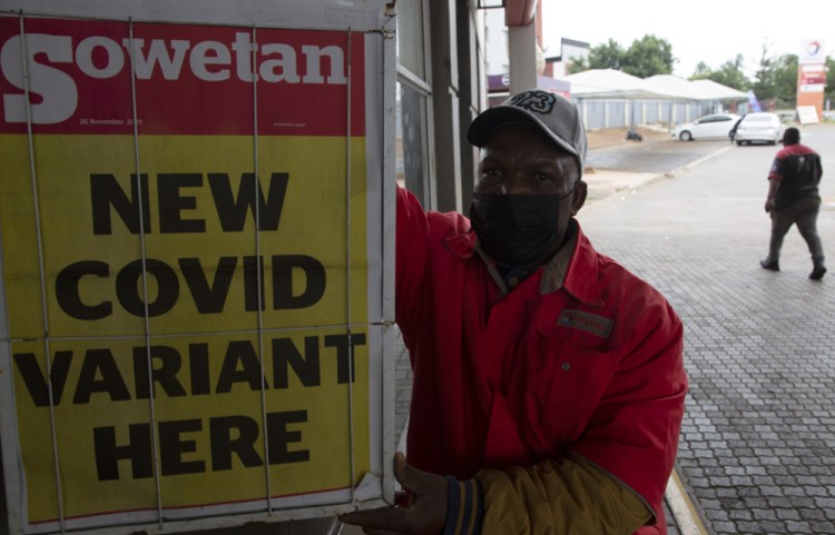 A petrol attendant stands next to a newspaper headline Saturday in Pretoria, South Africa.