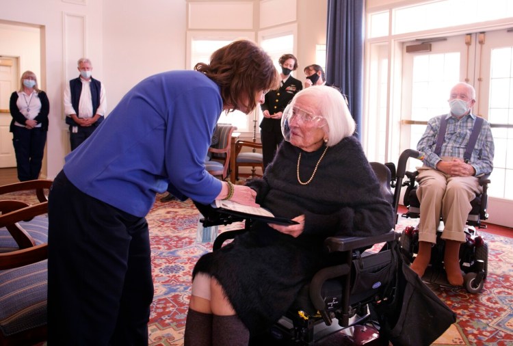 SCARBOROUGH, ME - DECEMBER 7: Joy Asuncion, a retired U.S. Navy Chief Petty Officer, hands a certificate of appreciation to Jane Case, who served as a code girl in the U.S. Navy WAVES during World War II. Case was honored for her service on Tuesday, the 80th anniversary of the Pearl Harbor attacks, at Piper Shores in Scarborough. (Staff photo by Gregory Rec/Staff Photographer)