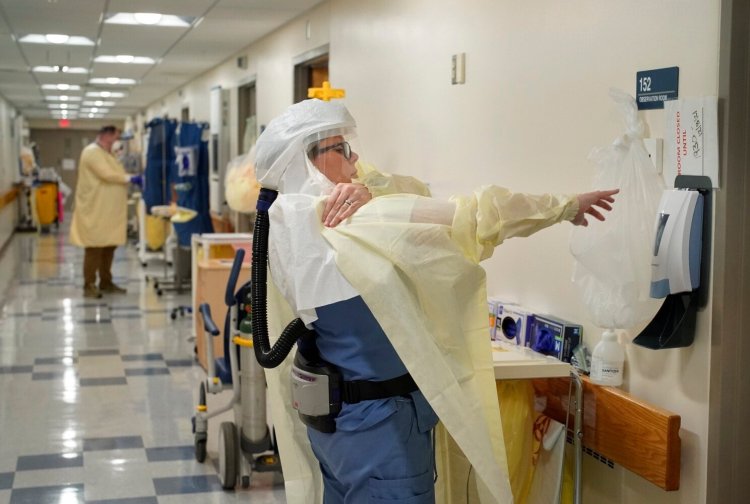 Taylor Bourque, an RN at Stephens Memorial Hospital in Norway, dons PPE while working in the negative pressure COVID-19 wing on Thursday. 