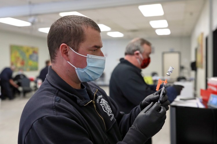 Adam St. Pierre of the Westbrook Fire Department fills a syringe with the Pfizer COVID-19 vaccine during a walk-in clinic at the Westbrook Community Center last week. 