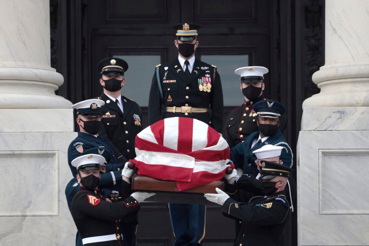 A military honor guard carries the flag-draped casket of former Sen. Bob Dole of Kansas from the U.S. Capitol in Washington on Friday after Dole's lying in state.