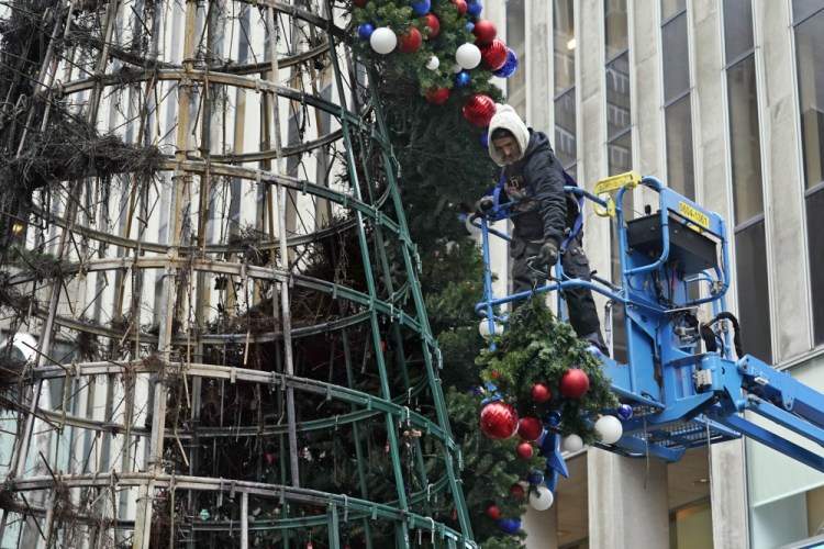 A worker takes apart an artificial Christmas tree outside Fox News headquarters in New York on Wednesday.

