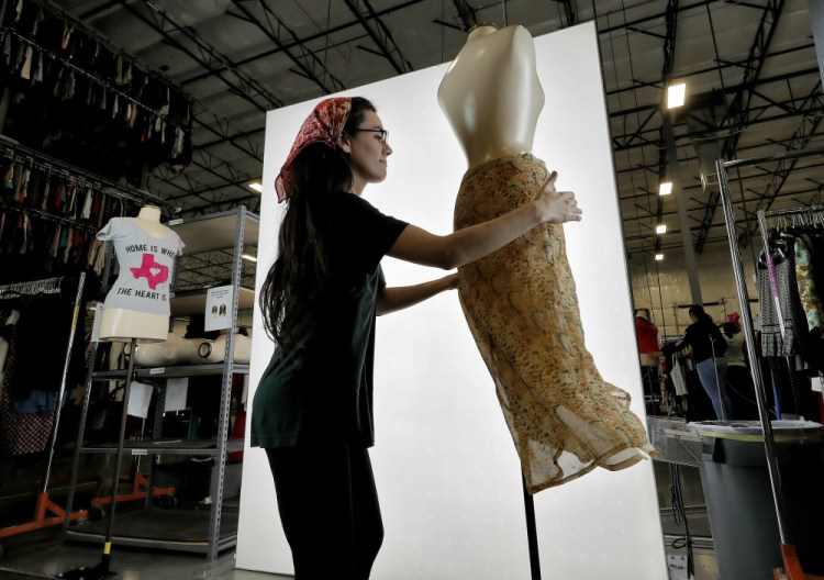 Samantha Estes prepares garments to be photographed at the ThredUp sorting facility in Phoenix on March 12, 2019. Sales of gift cards for the online thrift giant were up 103 percent during the first two weeks of December compared to the entire month of November, said Erin Wallace, vice president of integrated marketing.