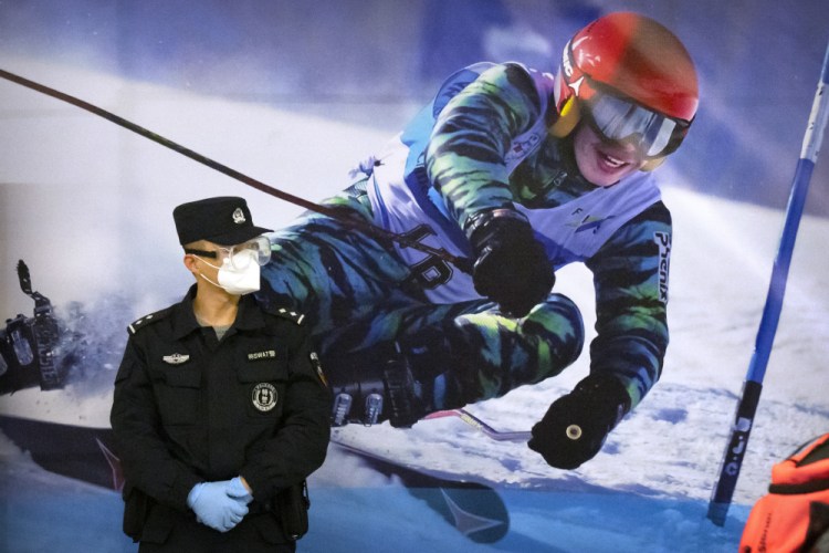 A police officer stands near a poster of a skier on the wall at a train station in Zhangjiakou in northern China's Hebei Province, in November.
