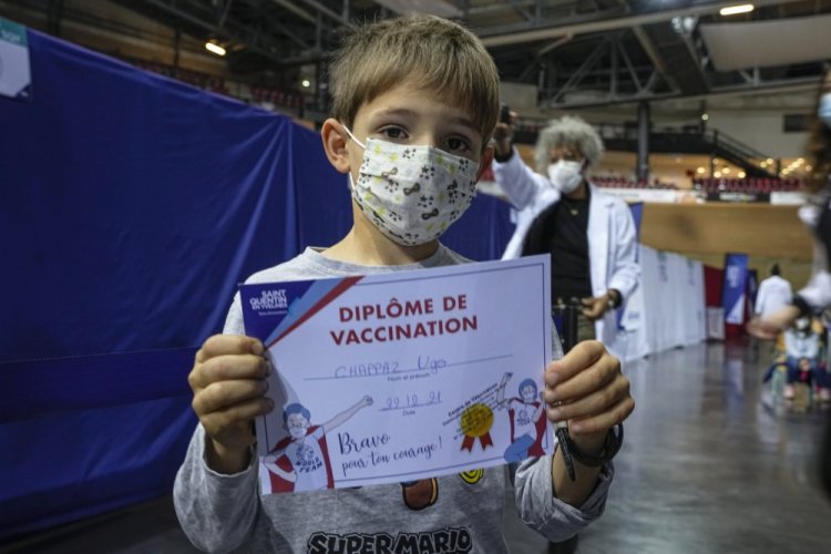 Hugo Chappaz, 9, displays his vaccination diploma at the National Velodrome in Saint-Quentin-en-Yvelines, west of Paris, on Wednesday.

