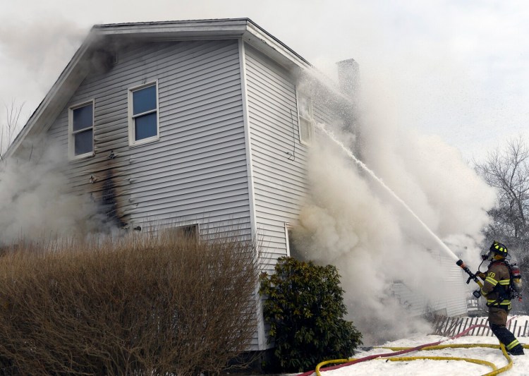 An Augusta firefighter sprays water Sunday at the upper story window of a Washington Street residence. After arriving at the scene, a second alarm was called for assistance. Chelsea, Vassalboro, Gardiner, Togus and Winthrop fire departments responded, while Hallowell’s department provided coverage for the city and Winslow Fire Department lent its ladder truck.