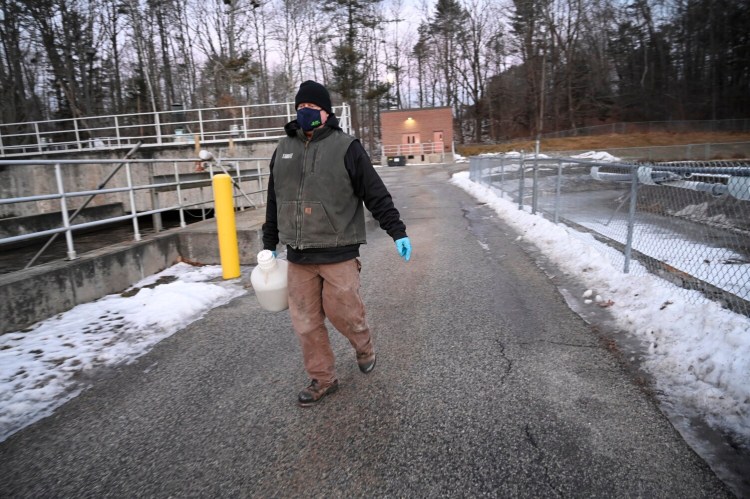 YARMOUTH, ME - JANUARY 18: Brian Leighton, chief operator at Yarmouth Wastewater Treatment Facility carries a container with wastewater to be tested for Covid 19 Tuesday, January 18, 2022. (Shawn Patrick Ouellette/Staff Photographer)