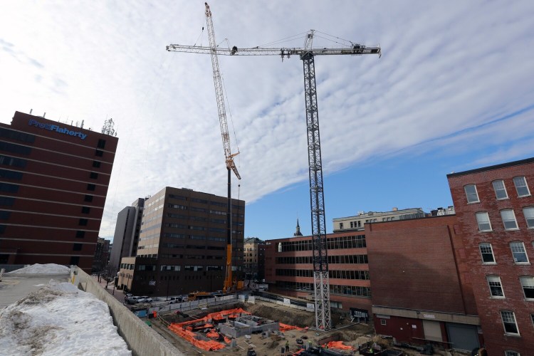 PORTLAND, ME - JANUARY 20: Workers erect a crane, right, with the use of a temporary, mobile crane at the construction site at the intersection of Federal and Temple streets on Thursday. (Staff photo by Ben McCanna/Staff Photographer)