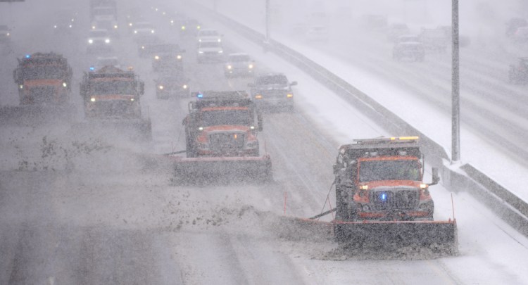Motorists trail a quartet of state of Colorado snowplows down Interstate 25 as a winter storm packing high winds and heavy snow moved across the intermountain West on Thursday in Denver. The storm then headed east.